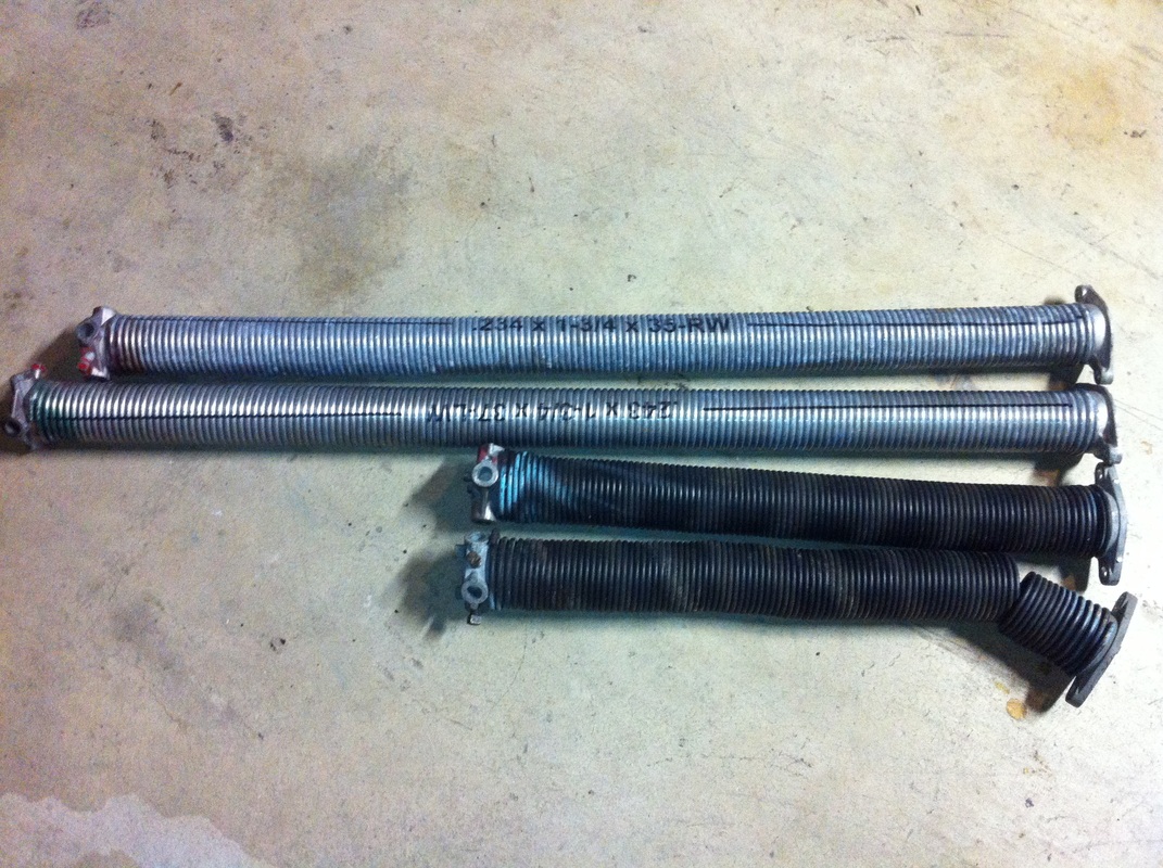 A pair of standard cycle oil tempered torsion springs next to a pair of high cycle galvanized torsion springs 4
