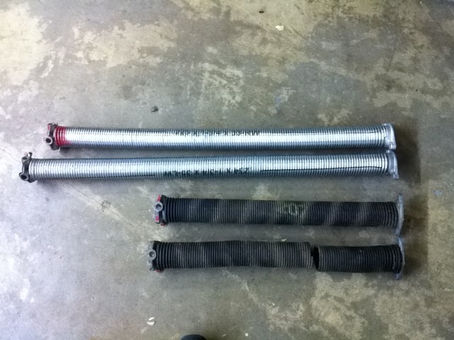 A pair of standard cycle oil tempered torsion springs next to a pair of high cycle galvanized torsion springs 3