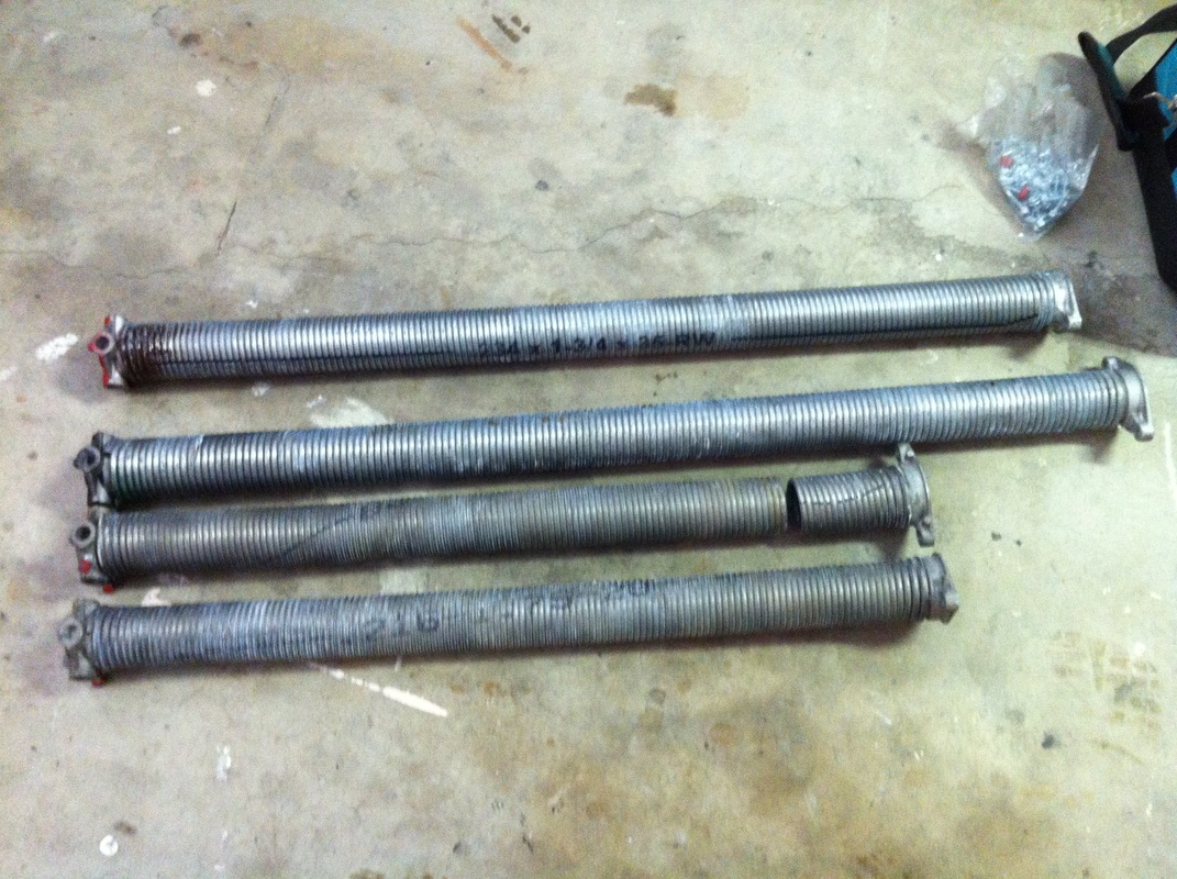 A pair of galvanized torsion springs next to high cycle galvanized torsion springs1